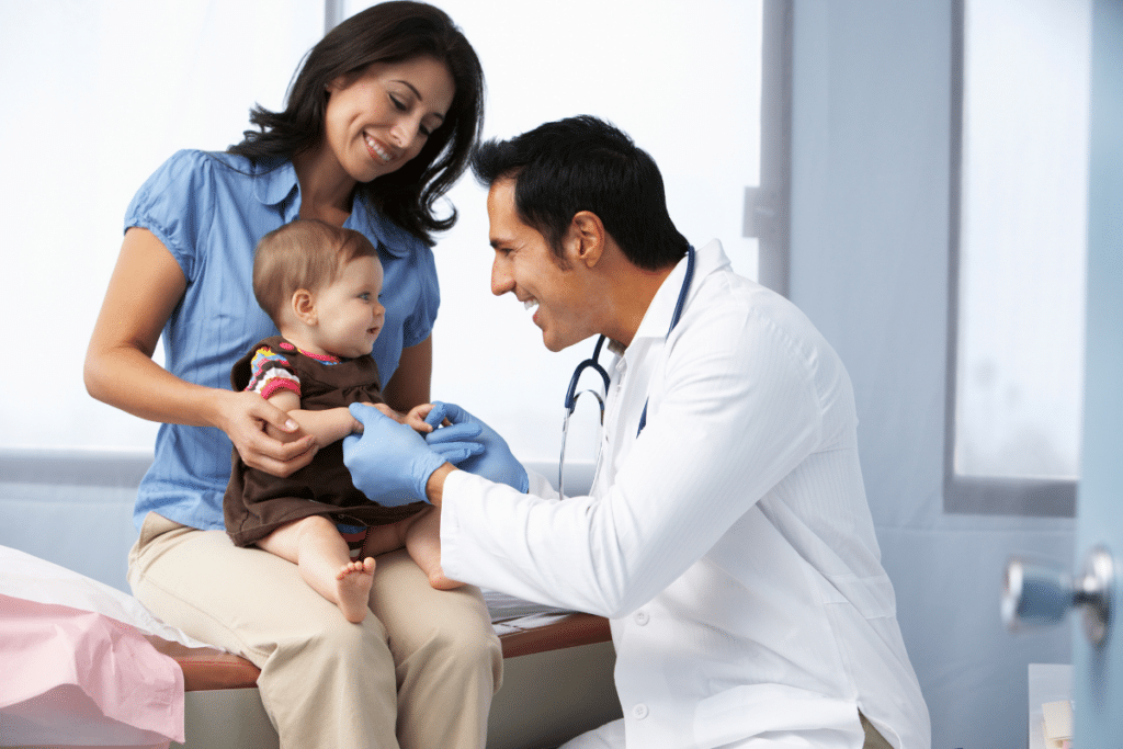 Image of a doctor playing with a baby patient and the baby's mother