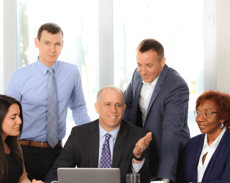 Florida medical malpractice attorneys Ray Valori, Michael Freedland and Dan Harwin with two paralegals sitting at a desk