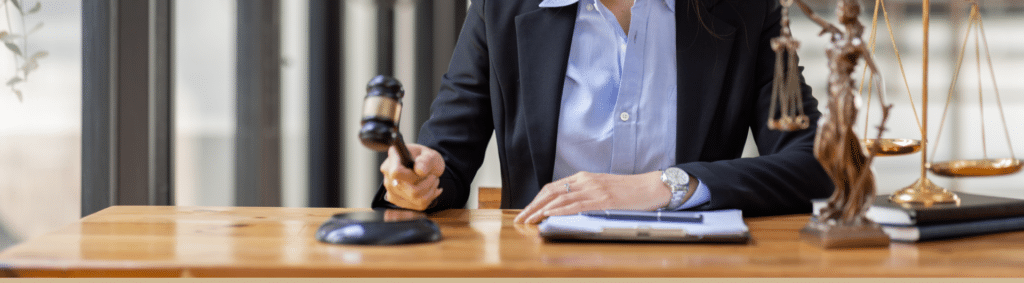 cropped image of an attorney holding a wooden ceremonial mallet used by judges.